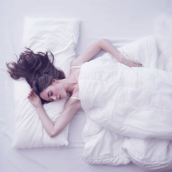 Young woman sleeping in bed, top view