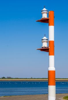 light pole for the ships at the harbor of tholen, Red with white striped lamppost