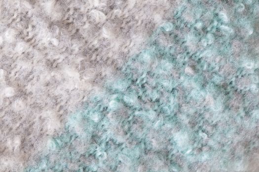 Woollen fluffy boucle scarf, macro. Soft pastel colors merino wool backdrop, closeup. Autumn and winter flat lay. Scandinavian minimal style.