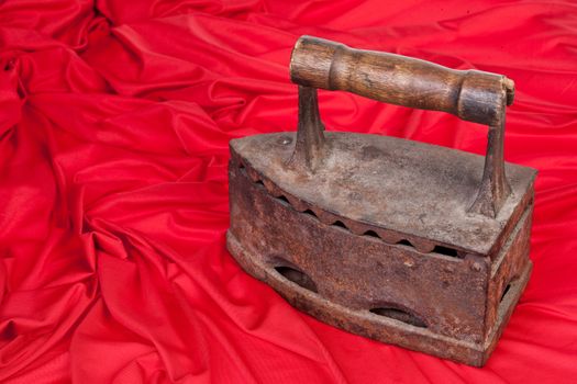 Old rusty iron and a piece or red textile on isolated background
