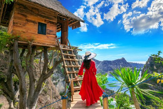 Young girl on steps of house on tree at Atuh beach in Nusa Penida island, Bali in Indonesia.