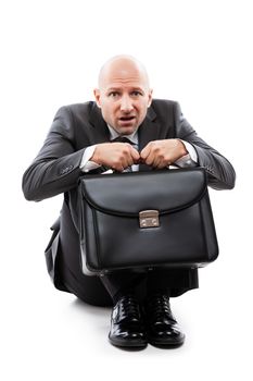 Business problems and failure at work concept - unhappy scared or terrified businessman in depression with fear and stress face expression hand holding briefcase sitting down floor white isolated