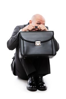 Business problems and failure at work concept - unhappy scared or terrified businessman in depression with fear and stress face expression hand holding briefcase sitting down floor white isolated