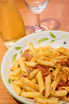 Pasta alfredo penne with tomato based sauce in plate