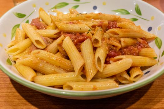 Pasta alfredo penne with tomato based sauce in plate