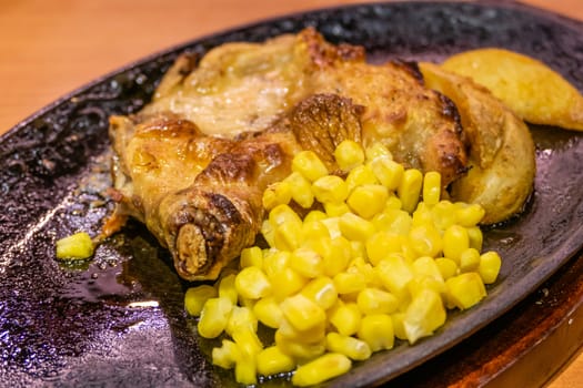 Chicken, French fries, and corn in metal plate