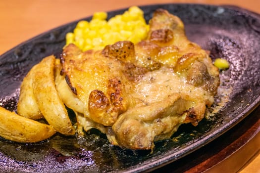 Chicken, French fries, and corn in metal plate