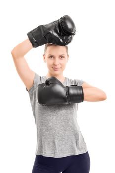 A portrait of a beautiful young girl with boxing gloves, arms raised, isolated on white background.