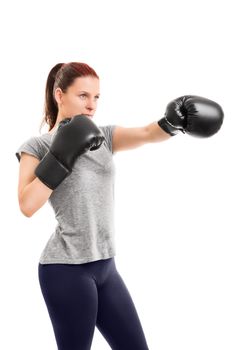 A portrait of a young beautiful girl with boxing gloves punching, isolated on white background.