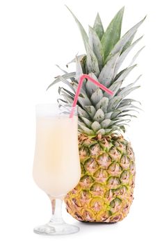 Uncut pineapple fruit next to a glass of juice with a straw, isolated on white background.