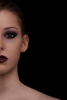 Low key beauty portrait of a young woman with sensual make up on, isolated on black background.