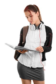 Going through my notes while the music is off. Beautiful young student in uniform with a backpack holding an open notebook, isolated on white background.