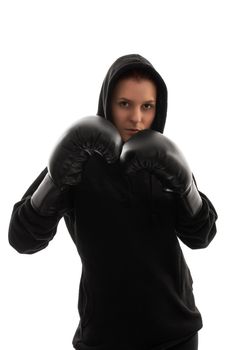 A portrait of a beautiful young girl with boxing gloves holding her guard up, with harsh lightning, isolated on white background.
