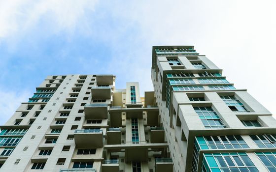 Low angle view of Modern skyscrapers Buildings in Kolkata City. Sunlight reflection, blue sky and white Fluffy clouds during sunset. Directly below view. Slanted, Tilt, diminishing perspective, Copy space room for text.