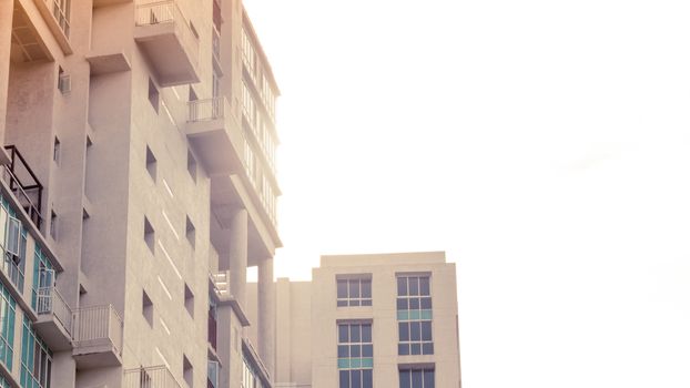 Low angle view of Modern skyscrapers Buildings in Kolkata City. Sunlight reflection on building illuminated by setting sun during sunset. Directly below view from distant. City life house building exterior at dusk.