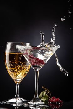 Bunch of red currant falling into the glass of water