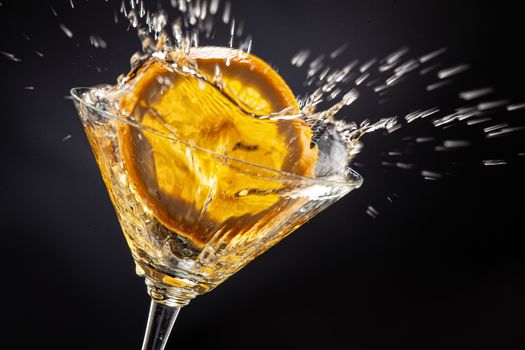 Slice of orange falling into the glass of juice