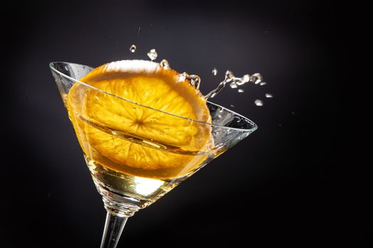 Slice of orange falling into the glass of juice