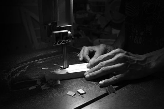 Carpenter builder working with electric jigsaw and wood. Woodworker cutting a piece of wood  
