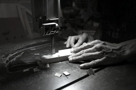 Carpenter builder working with electric jigsaw and wood. Woodworker cutting a piece of wood  