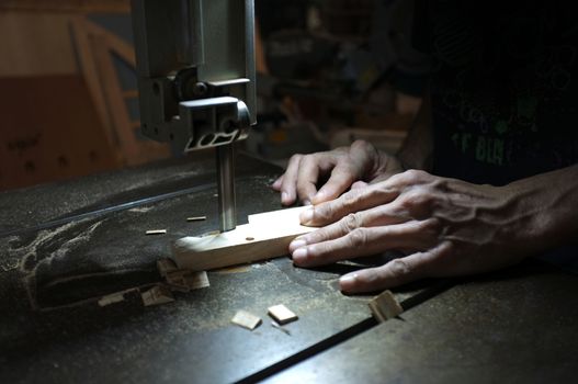 Carpenter builder working with electric jigsaw and wood. Woodworker cutting a piece of wood  