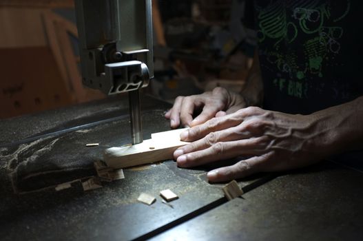 Carpenter builder working with electric jigsaw and wood. Woodworker cutting a piece of wood  