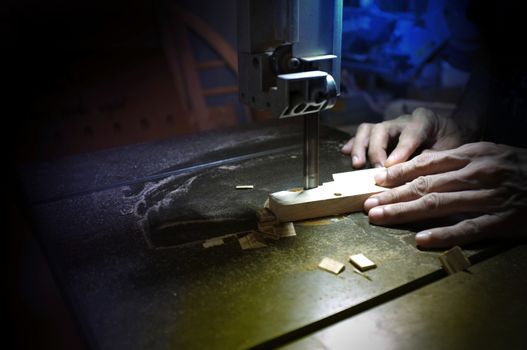 Carpenter builder working with electric jigsaw and wood. Woodworker cutting a piece of wood  