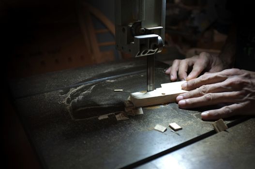 Carpenter builder working with electric jigsaw and wood. Woodworker cutting a piece of wood  