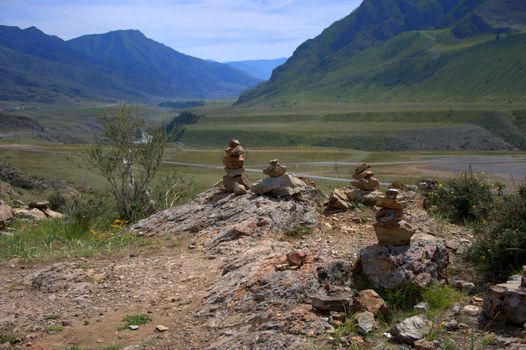 A sacred stone cairn on top of a mountain overlooking the valley. Altai, Siberia, Russia.