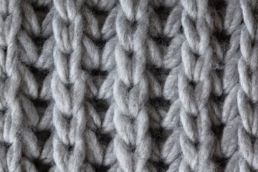 Knitted woolen textured surface, macro. Soft grey merino wool pattern backdrop, closeup. Autumn and winter flat lay. Scandinavian minimal style.