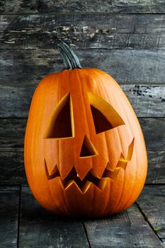Halloween pumpkin head jack o lantern on wooden background