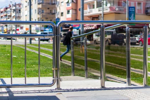 a shoot from tram station with green grasses - there is a man walking. photo has taken from izmir/turkey.