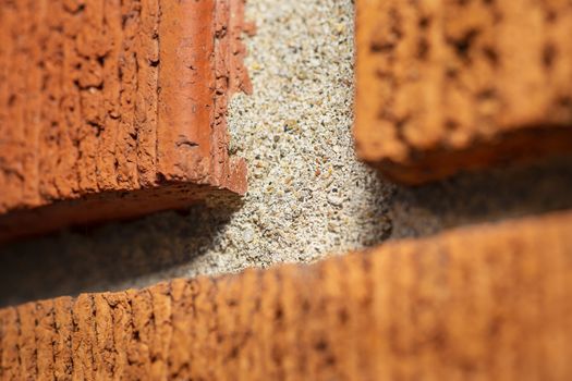 Macro shot of a jonction of red brick on a wall