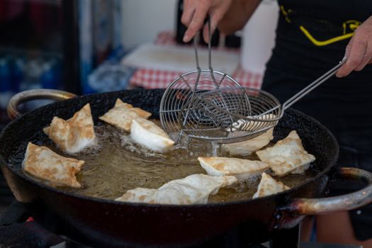 Dumplings fried,Deep Frying in hot oil pan, street food during the day,italian traditional food.