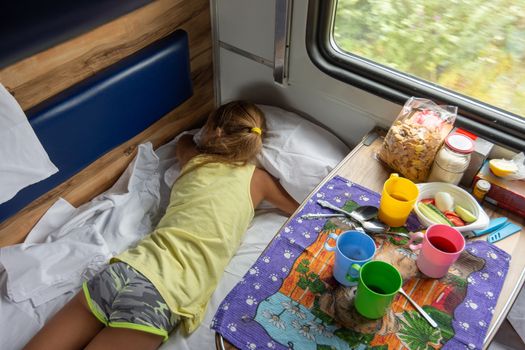 Girl sleeping on the bottom shelf in the train