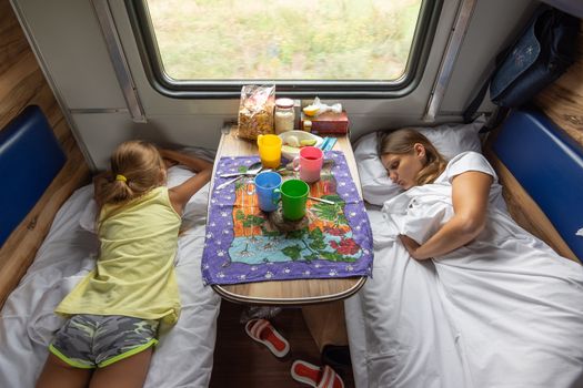 The situation on the train, mom and daughters are sleeping on the lower shelves in the car