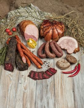 Ham and vegetables on an old wooden background