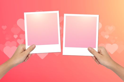 Hands hold Blank photo frame on pink Valentines Day Background Design.