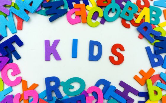 The letters made of plywood the words kids are on a white background.