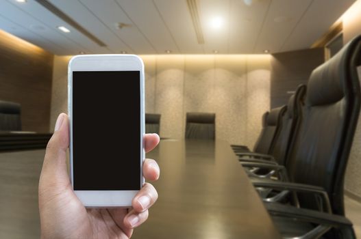 Man's hand shows mobile smartphone in vertical position and blurred background - smartphone mockup template