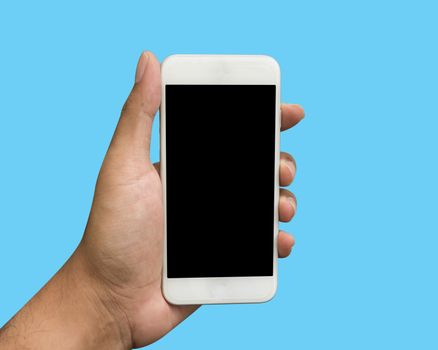 Hand holding white smart phone isolated over blue background.