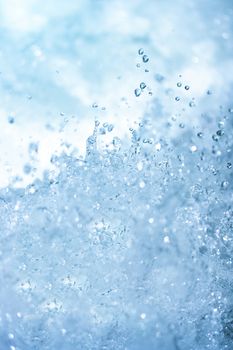 Blue water splash background from nature waterfall in rainforest. Portrait position.