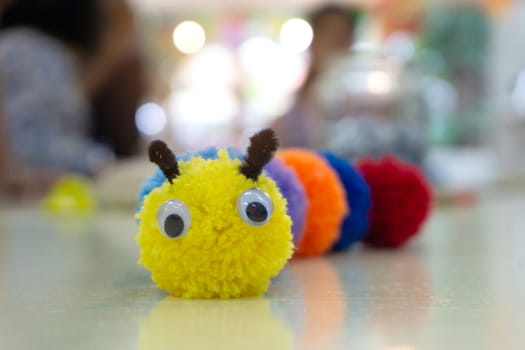 Handmade colorful worm doll and blurred background.