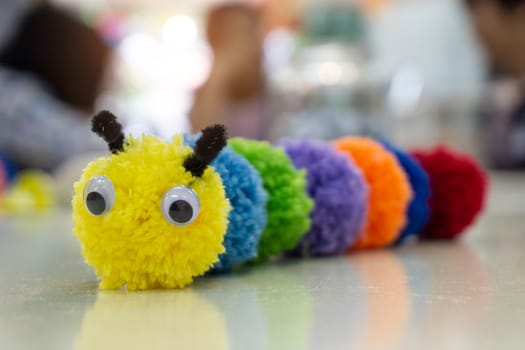 Handmade colorful worm doll and blurred background.