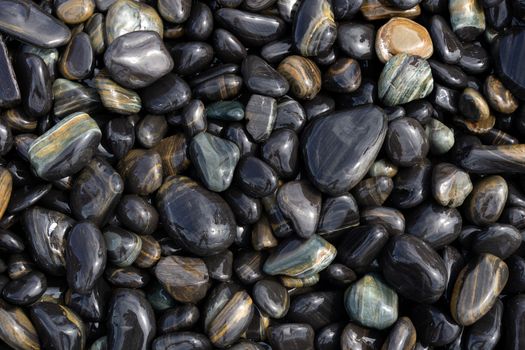 Wet Black pebble stones island in Koh hin ngam, Tarutao National Park, Satun, Thailand.