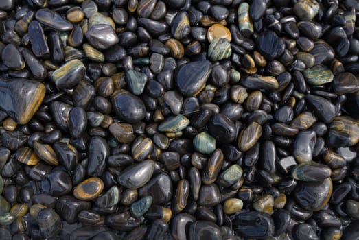 Wet Black pebble stones island in Koh hin ngam, Tarutao National Park, Satun, Thailand.