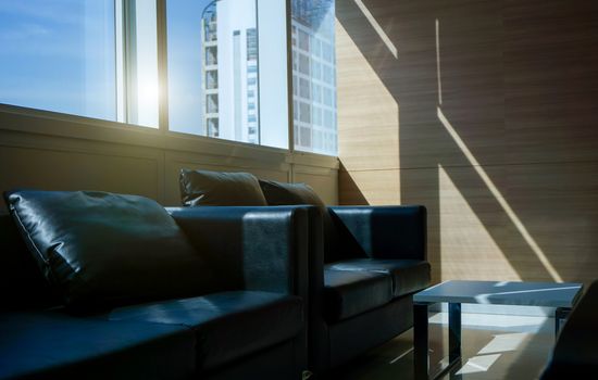 Black sofa interior of a waiting room in office and Building view outside.