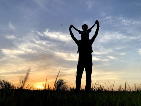 Silhouette Father Carrying Son Against Sky During Sunset.