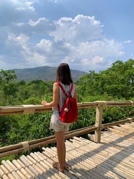 Rear View Of Woman Standing On Footbridge Against Sky.