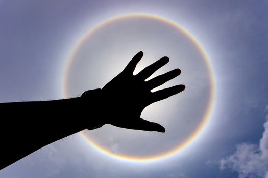 Silhouette hand on sun Halo background for powerful concept.